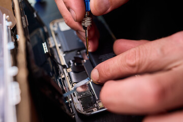 Technician repairing circuit, Closeup of skilled technician fixing smartphone circuitry, Focused...