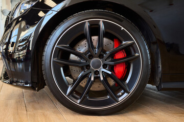 High-resolution alloy wheel detail, Focus on vehicle rim and brake assembly, Detailed photograph emphasizing intricacies of automotive alloy wheel and brake mechanisms