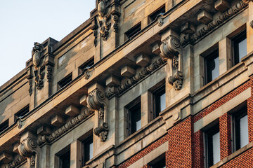 Obraz premium Detailed view of historic architecture with ornate stonework and red brick facade in downtown Montreal, Quebec