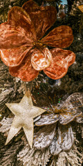 Golden and silver velvet flowers with glitter star on snowy Christmas tree. Selective focus