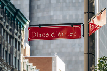Obraz premium Montreal, Canada - August 11, 2025: Red street sign of Place d’Armes in Old Montreal on a sunny day