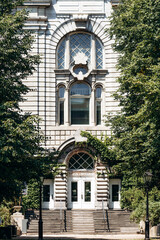 Montreal, Canada - August 11, 2025: Historic building facade surrounded by green trees in Old Montreal