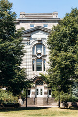 Montreal, Canada - August 11, 2025: Historic building facade surrounded by green trees in Old Montreal