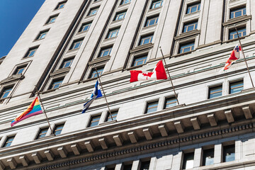 Facade of the historic Sun Life Building with Canadian and Quebec flags in downtown Montreal