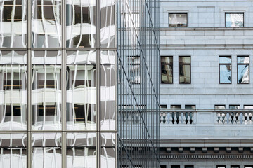 Architectural details with glass reflections and stone facade, modern and historic downtown Ville-Marie buildings, Montreal, Canada