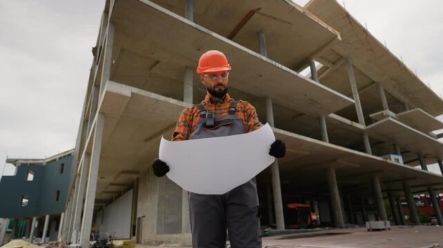 Architect holding blueprint supervising construction project site