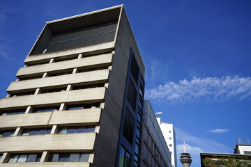 Buerogebaeude mit moderner Fassade im Sommer vor blauem Himmel im Sonnenschein mit Fernsehturm im Hintergrund am Medienhafen in der Landeshauptstadt Duesseldorf am Rhein