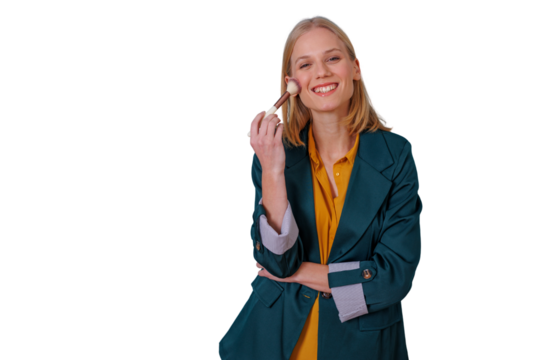 Young blonde woman smiling, applying blush with makeup brush, showcasing beauty and cosmetics routine