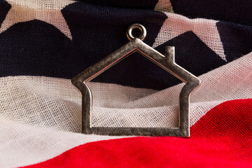 a figurine of a house against the backdrop of the US flag