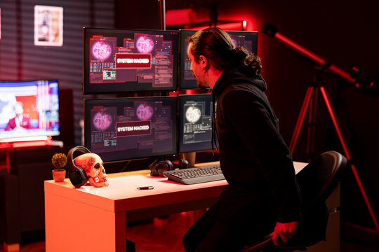 Hacker scared after watching news program unveiling his phishing attacks stealing credit cards data. Man feeling afraid after seeing breaking news on police on lookout for him after DDoS attacks - Powered by Adobe