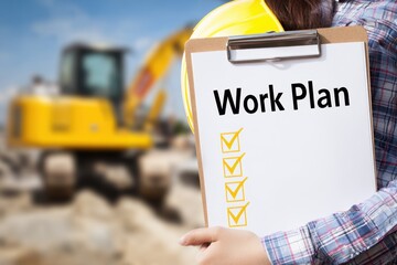 A construction worker holds a clipboard with a work plan document and a hard hat in front of heavy machinery on a sunny day at a busy construction site outdoors