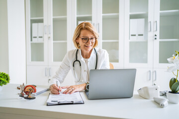 Mature female doctor providing online medical consultation