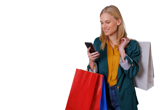 Happy young woman shopping, holding colorful bags and using smartphone for online checkout or messaging