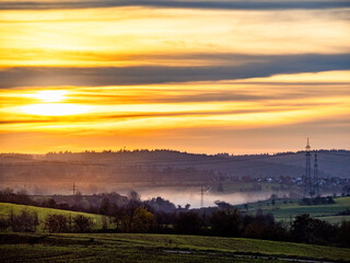 Hochspannungsmasten in einer Staubwolke bei Sonnenuntergang
