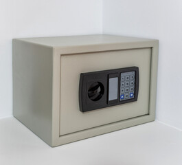 A modern electronic safe sits in a home corner, featuring a keypad and lock, perfect for securing...