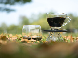 Drip coffee on the autumn morning grass