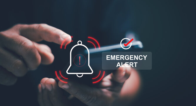Emergency alert concept. Hand holding smartphone with notification symbol and a warning icon. Rapid communication, public safety and instant mobile alerts for urgent situations and critical response.