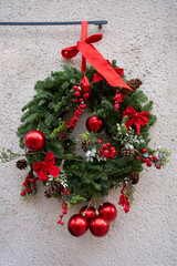 Christmas wreath made of pine branches, pine cones, and red berries