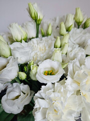 Elegant bouquet of white eustoma and carnation flowers with soft natural light. White Eustoma and Carnation Flowers Bouquet Close-Up.