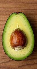 Freshly cut ripe Hass avocado half displayed on a natural surface, highlighting the creamy green flesh and large brown seed for health ,cut ,natural ,nutrition