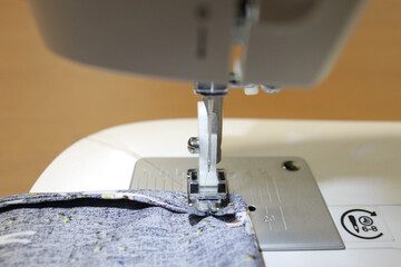 Sewing machine close up with a needle and apiece of fabric. Sewing and machine selection. Indoor activities  and clothing manufacturing.