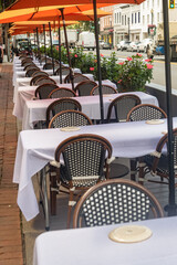 Sidewalk dining area set for guests under tent cover in urban downtown