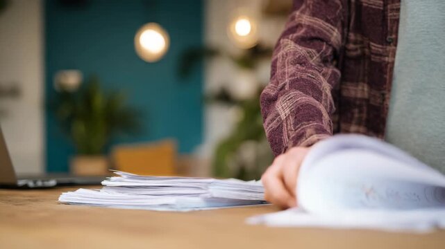 Medium shot of a landlord reviewing rental application documents assessing tenant background for reliable housing history and references