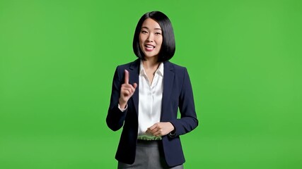 A smiling young Asian businesswoman pointing upwards, wearing a dark blazer and white shirt on a green screen background. Perfect for presentations, explainer videos, or corporate - Powered by Adobe