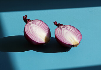 Minimalist Composition: Sliced Red Onions on a Bold Blue Background with Dramatic Lighting