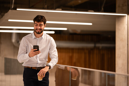 Smiling man using smartphone during coffee break
