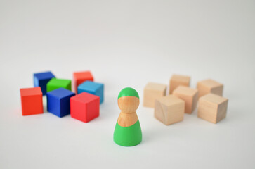 Wooden figure choosing between diverse and uniform groups