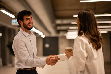 Business man and woman shaking hands laughing