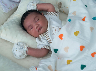 Cute newborn baby boy sleeping peacefully in white crib and soft nest. Close-up of infant resting on bed, symbolizing childhood innocence, comfort, and family love. Perfect for baby care themes.