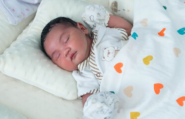 Cute newborn baby boy sleeping peacefully in white crib and soft nest. Close-up of infant resting on bed, symbolizing childhood innocence, comfort, and family love. Perfect for baby care themes.