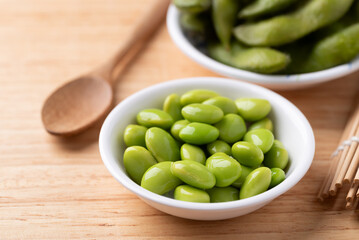 Boiled Edamame beans (Japanese soybeans) in a bowl on wooden background