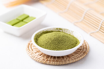 Matcha powder and chocolate bar on white background