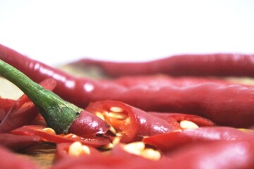 The fresh curly red chilies or capsicum annuum on an old wooden cutting board