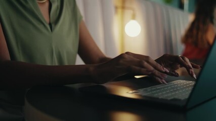 Closeup shot of smiling black businesswoman working on laptop in office lounge - Powered by Adobe