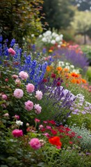 Obraz premium Colorful flowering garden with pink roses, blue delphinium, and lavender blossoms creating a vibrant landscape for backyard and country living.