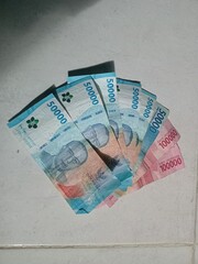 Money Shot: Indonesian Currency Lying on a Tile Floor. Rupiah for Business, Economy, and Wealth Concepts Background.