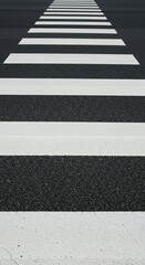 Abstract background featuring the broad white safety stripes of a typical pedestrian crossing area painted directly onto the asphalt street surface ,urban ,area ,wide