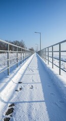 An empty concrete walkway blanketed in pristine white snow under a frosty winter sky, conveying a tranquil yet cold atmosphere ,shadow ,background ,pavement