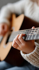Child learning to play guitar with focused hand plucking strings
