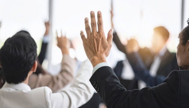 Business Team Raising Hands to Vote or Ask Questions in Meeting with Office.