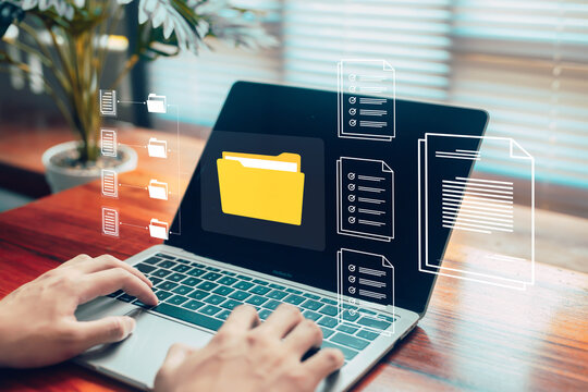 Hands managing digital folders and documents on a laptop, representing organized file management, cloud data storage, efficient workflow systems, and modern digital documentation in a professional