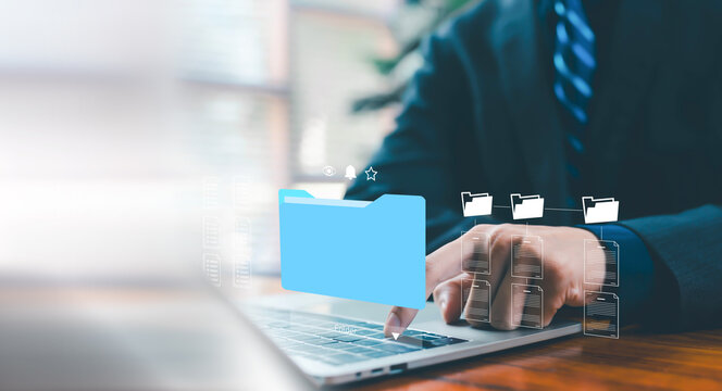 Business professional organizing digital folders on a laptop, representing efficient file management, data organization, cloud storage solutions, and streamlined workflow processes in a modern digital