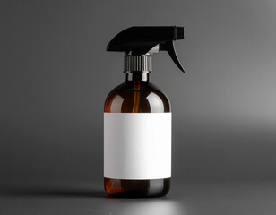 Minimalist dark brown glass spray bottle with a blank white label and black trigger sprayer, standing on a dark surface. Cleaning or hair product branding.