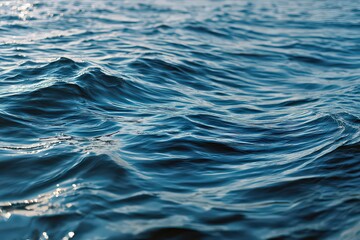 Naklejka premium Close Up View Of Blue Ocean Water Waves with Sunlight Reflections Creating Abstract Patterns