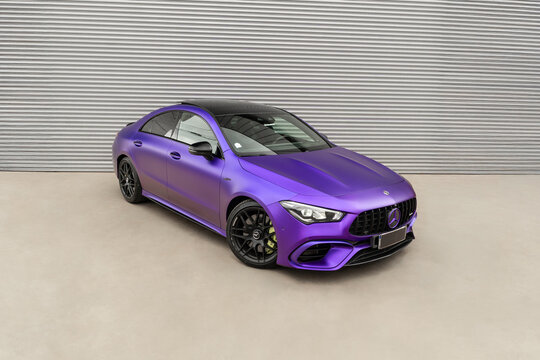 Matte purple Mercedes CLA 45s front view three quarters, Performance coupe parked against metal shutter background