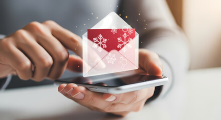 A person's hands holding a smartphone with a digital email icon featuring a festive holiday design, representing communication.